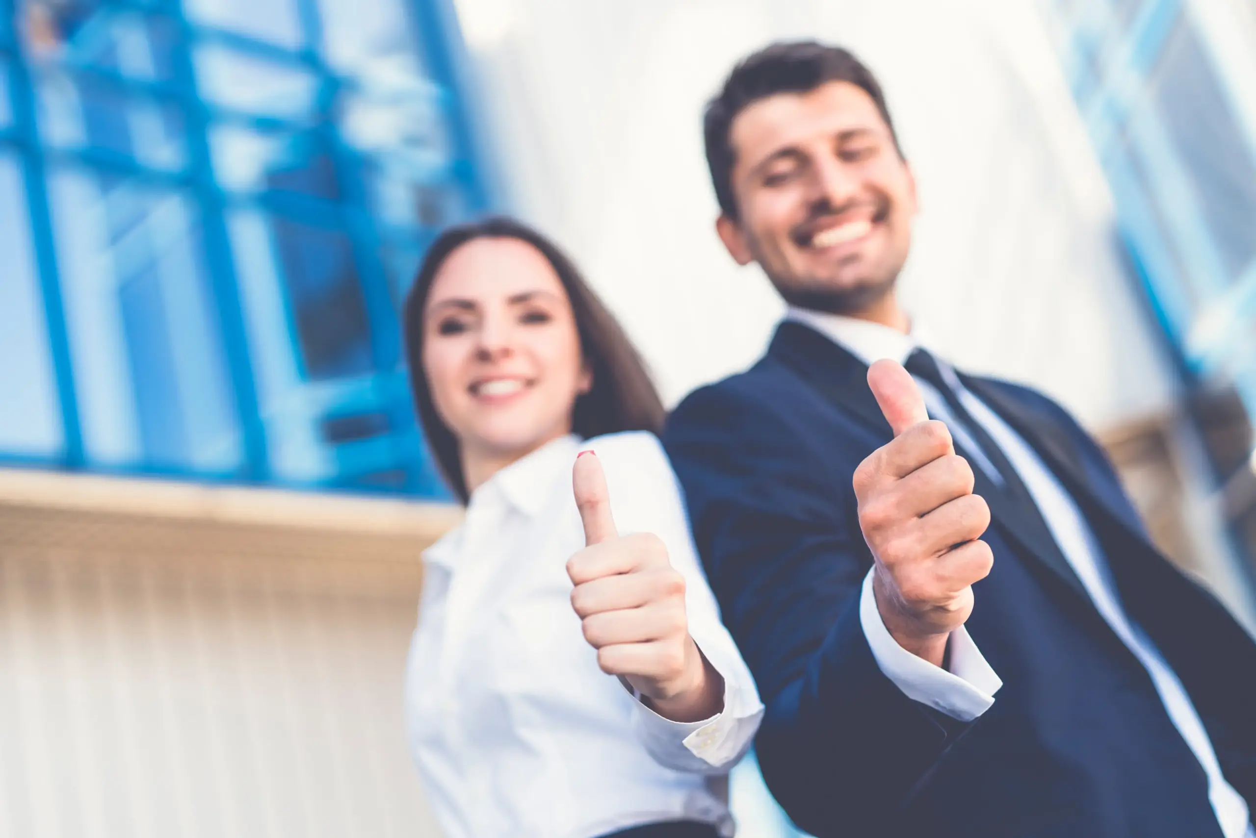 Zufriedene Mitarbeitende durch modernes HR-Management Zwei zufriedene Mitarbeitende zeigen einen Daumen nach oben.