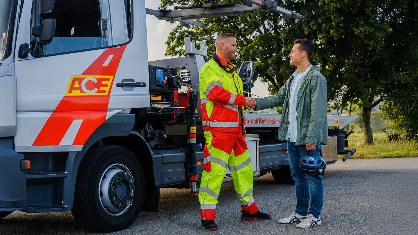 ACE Pannenhilfe für Mitglieder ACE-Pannenhelfer begrüßt ein Mitglied vor einem Einsatzfahrzeug des Automobilclubs.